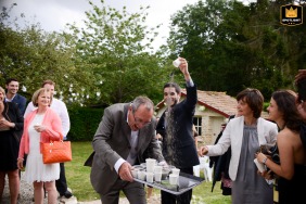   During a backyard ceremony near Normandy, France, a family member, tasked with handing out petals, gets a playful surprise as others dump a few on his head for fun.